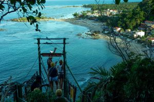 Tutores descendo em Tirolesa do alto do Morro do Farol até a primeira praia da vila