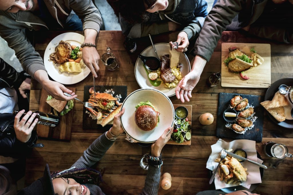 Amigos todos juntos no restaurante fazendo uma refeição.