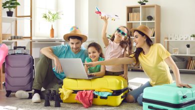 Família animada arrumando as malas e mexendo no notebook